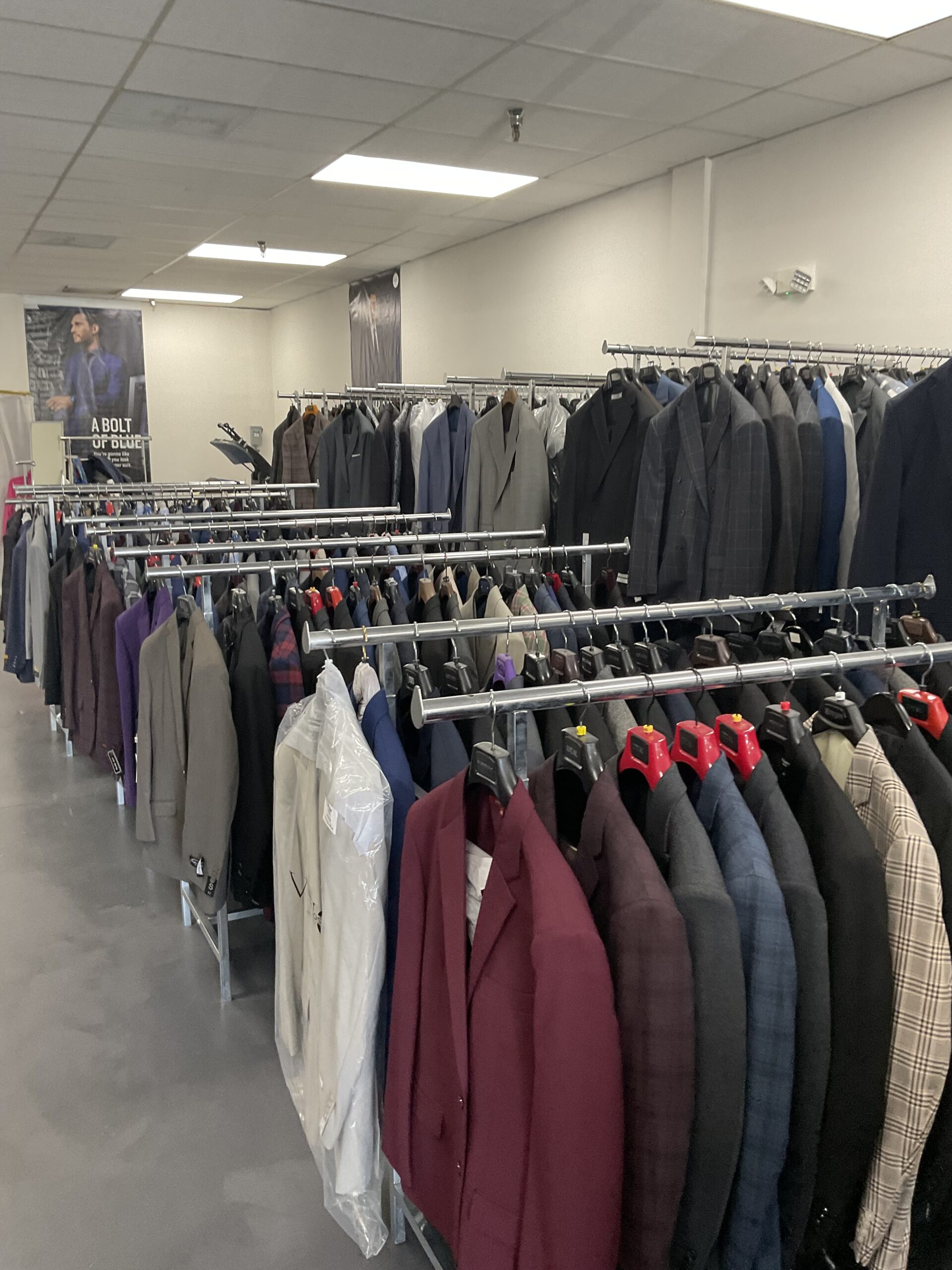 Interior store image showing all the different suits that St Laurent Men's Suits & Dry Cleaners has
